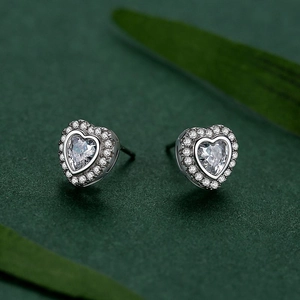 Sparkling S925 sterling silver heart halo stud earrings on elegant green leaf background