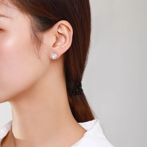 Elegant S925 sterling silver heart stud earrings with sparkling cubic zirconia on model