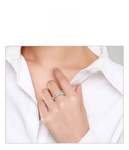 Close-up of a sterling silver baguette eternity ring worn by a model on white background