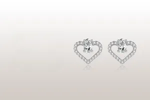 Gros plan de boucles d'oreilles cœur en argent avec diamants et pierre centrale