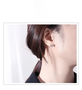 Gros plan d'une élégante boucle d'oreille cœur en argent s925 avec pierres sur un mannequin