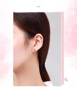Close-up of s925 silver crown earring with black star detail and diamonds on ear