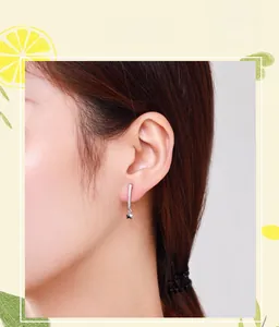 Detailed macro shot of elegant S925 sterling silver star drop earrings on female model