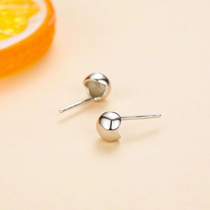 S925 sterling silver bubble stud earrings with a polished mirror finish on orange background