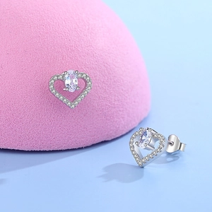 Boucles d'oreilles cœur en argent 925 avec cristaux brillants sur fond de studio élégant