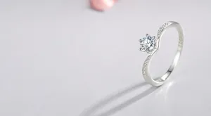 Detail van een S925 zilveren ring met 6-klauws solitair en zijwaartse pavé diamantzetting