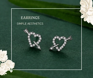 Macro view of S925 sterling silver heart earrings with arrow and micro-pave crystals