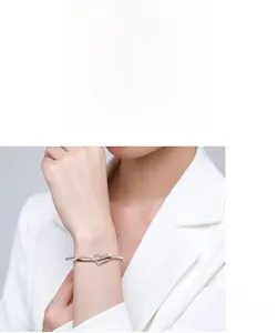 Detail of s925 silver heart bracelet featuring paved zircons on a female wrist