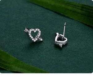 Macro view of S925 silver heart studs with cubic zirconia and Cupid's arrow detail