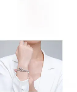Detailed view of an S925 silver leaf bracelet with sparkling zircons on a model's wrist