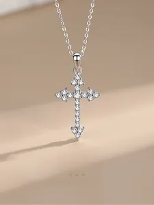 Macro shot of 925 sterling silver cross pendant with pavé sparkling zircon stones