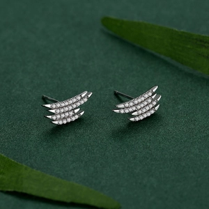 S925 sterling silver geometric wing stud earrings with pavé zircons on green background