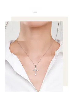 Close-up of 925 sterling silver cross necklace with pavé cubic zirconia on model neck