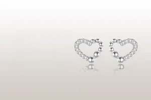 Detail of silver S925 heart earrings with pavé zirconia and beaded design