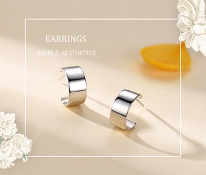 Macro shot of minimalist silver C-shaped hoop earrings with polished surface detail