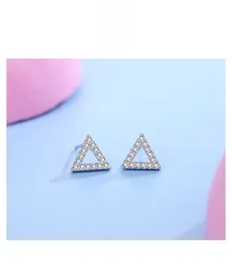 Macro detail of S925 silver triangular stud earrings with shimmering pave-set cubic zirconia