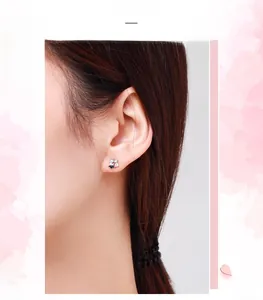 Close-up of S925 sterling silver square zircon stud earrings worn by a female model