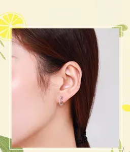 Close-up of S925 sterling silver C-shaped earrings with zircons worn by a model