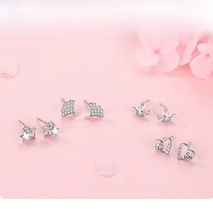 Macro detail of S925 silver stud earrings set featuring star and heart zircon designs