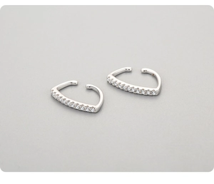 Detail of silver S925 ear cuffs with sparkling round-cut cubic zirconia inlays