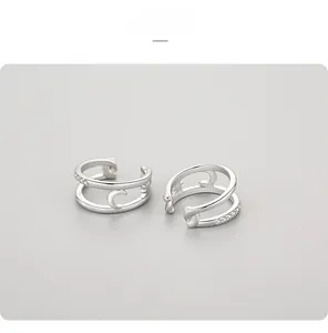 Macro detail of 925 sterling silver ear cuffs with moon star patterns and pavé micro-diamonds