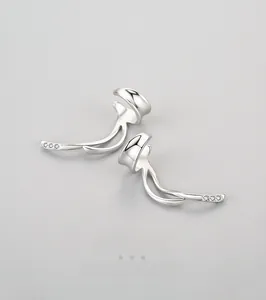 Dettaglio macro di orecchini a clip in argento S925 con linee doppie e piccoli zirconi