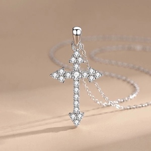 Elegant 925 sterling silver cross necklace with pavé zirconia on a beige background
