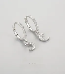 Gros plan de boucles d'oreilles lune en argent avec zircons incrustés et fermoir élégant