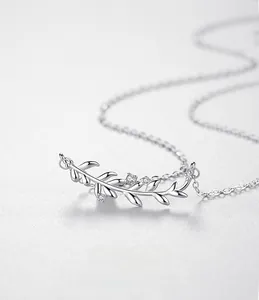 Detailed close-up of S925 silver leaf pendant with three sparkling zircons on a fine chain