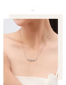 Close-up of S925 silver leaf pendant necklace with micro-diamonds on a female model
