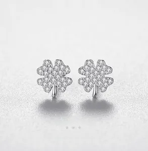 Detailed macro view of S925 sterling silver four-leaf clover earrings with pavé crystals