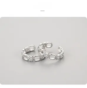 Detail of silver chain ring featuring star motifs and small inlaid zircon crystals
