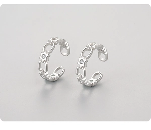 Macro shot of silver ear cuffs featuring hollow star and oval link chain detail