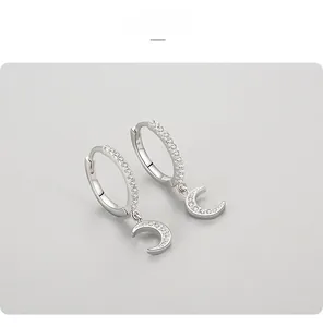 Détails macro de boucles d'oreilles créoles lune en argent S925 avec zircons scintillants