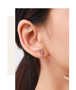 Close-up of s925 silver leaf earrings with sparkling cubic zirconia on model's ear