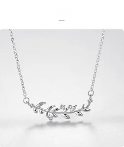 Macro shot of silver leaf pendant necklace with three small clear zircon accents