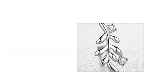 Macro detail of leaf-shaped silver earrings featuring handcrafted zircon stone settings