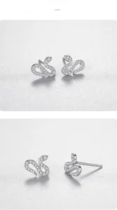 Macro detail of snake-shaped S925 silver stud earrings with sparkling pavé zircons