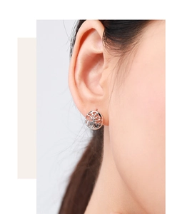 Close-up of S925 sterling silver Tree of Life earrings worn on a model's ear lobe