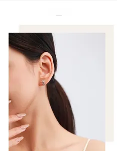 Close-up of elegant s925 silver daisy stud earring with micro-pave zircons on model ear
