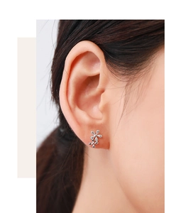 Close-up of S925 sterling silver daisy stud earrings with zircon inlay on model's ear