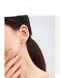 Detail of S925 sterling silver cherry earrings with sparkling crystals on a model's ear