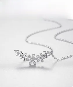 Macro shot of silver daisy necklace pendant with five flowers and sparkling zircon stones