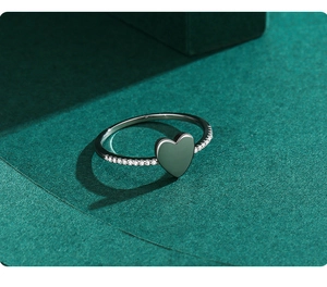 Macro detail of silver heart ring with sparkling pavé cubic zirconia on textured background