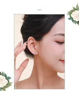 Gros plan de boucles d'oreilles esperluette en argent S925 avec zircons portées par un mannequin
