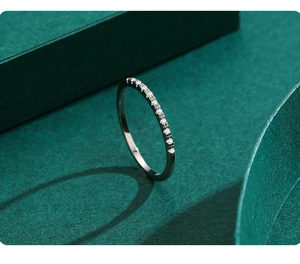 Macro shot of s925 silver stackable band ring with sparkling pavé zircons on green texture