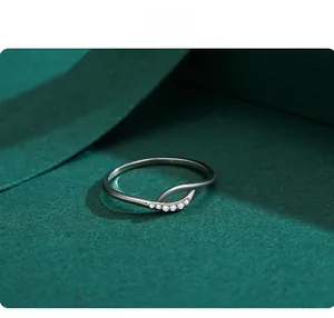 Detail of S925 silver cross ring with sparkling cubic zirconia on green background