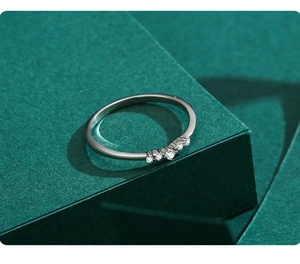 Macro shot of minimalist silver ring with five micro-set sparkling round cubic zirconia gems
