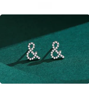 Vue macro des boucles d'oreilles esperluette en argent S925 avec pavé de zircons blancs