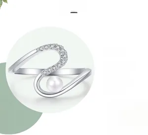 Détail macro d'une bague serpent en argent s925 avec pavé et perle blanche